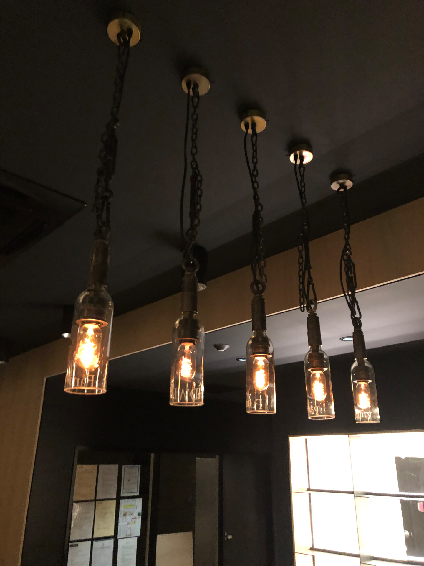 Bottle pendant lights suspended on chains