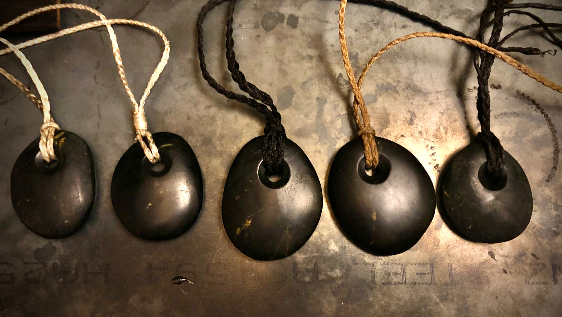 Collection of dark metal pendants on hand-braided cords